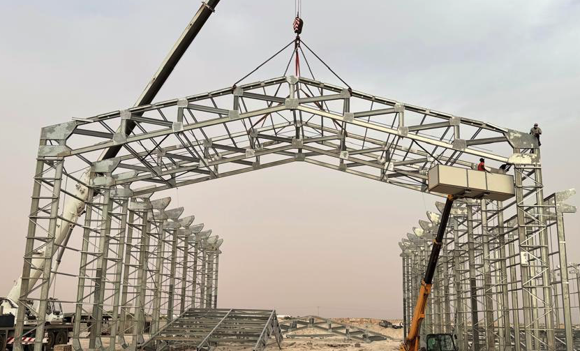 Large steel truss being lifted by crane